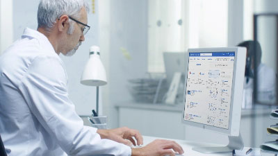 lab worker looking at large displaying Inventory Manager software